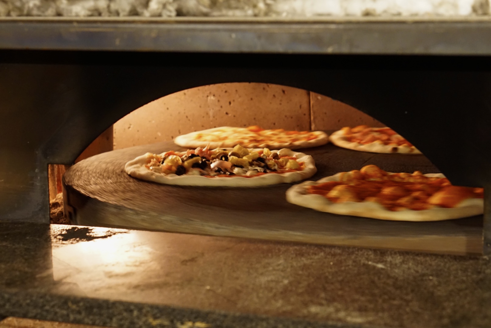 Zwei Pizzen werden im traditionellen Steinofen gebacken